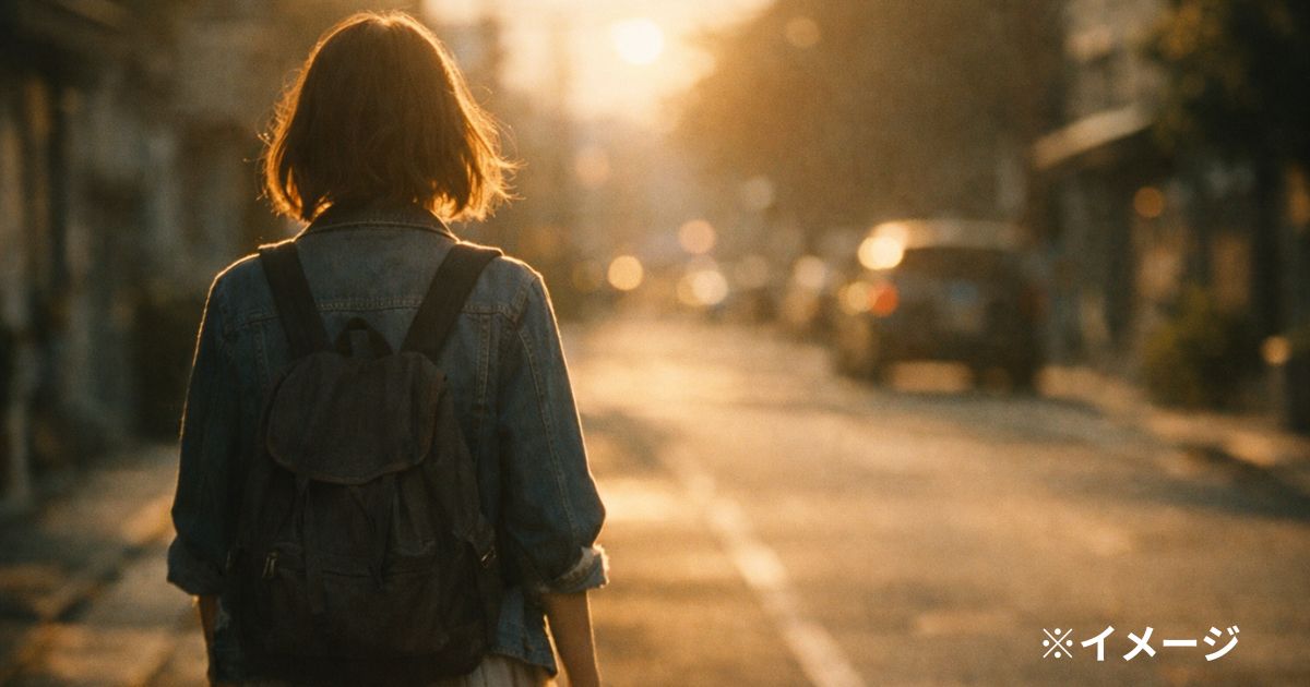 夕日を背に歩く女性